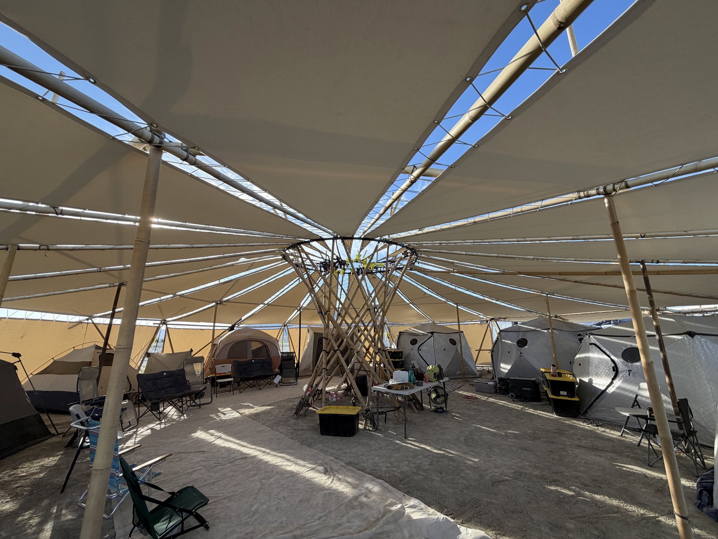 Under the Resonance Pavilion: the canopy spread on radial bamboo spokes around a woven central column