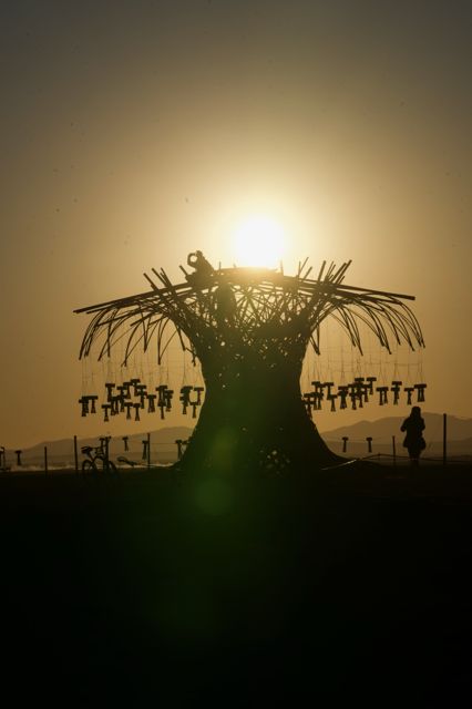 Sun over the top: sunrise silhouette with a climber up high.