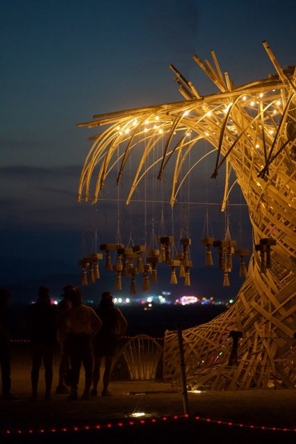 Blue hour: the tree lit gold, visitors at the rope.